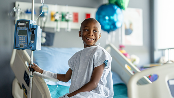 Young smiling child sitting in hospital bed