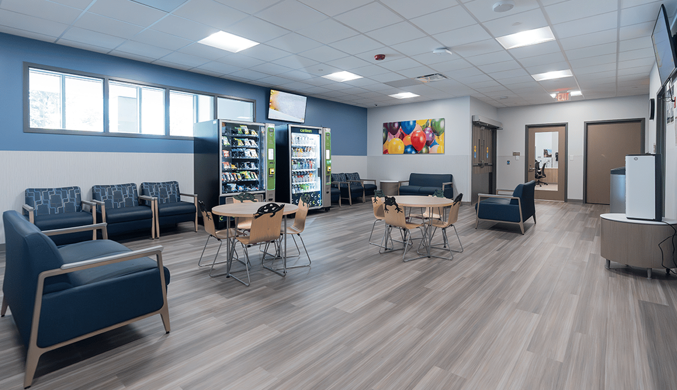 Patient waiting area with tables, chairs and vending machines.