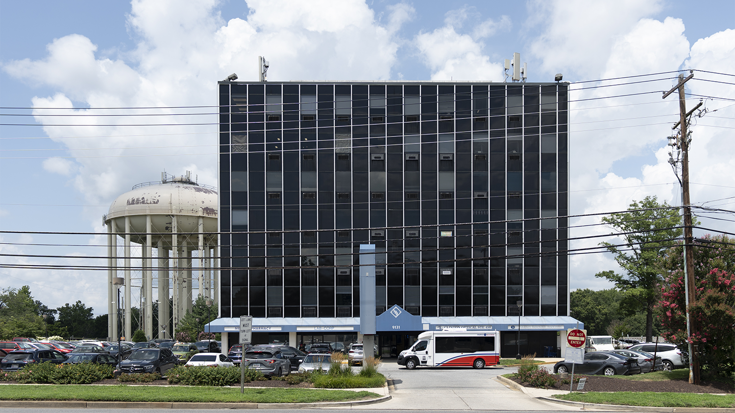 Tall multi-floor building with a water tower in the background.