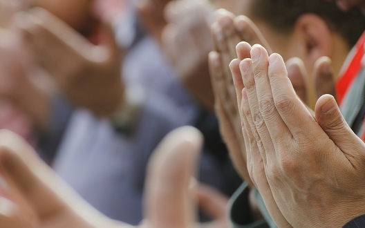 The hands of Muslim men lifted in prayer