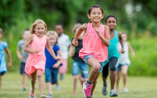 Kids running outside at a summer event