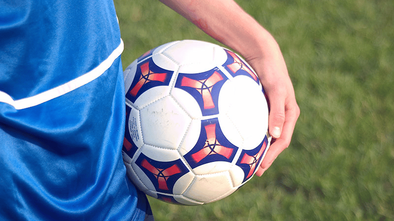child holding soccer ball
