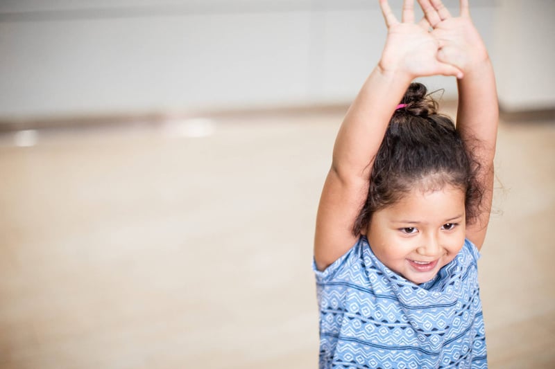 Young Girl Smiling with Arms Up