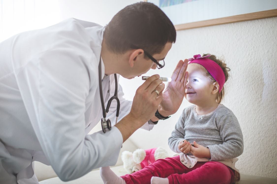 provider shining a light in a young girl's eye, neurology evaluation