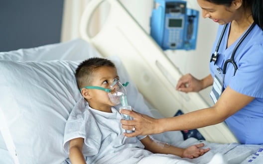 Boy in hospital receiving anesthesia through a mask