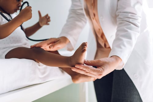 provider examines a baby's leg and foot