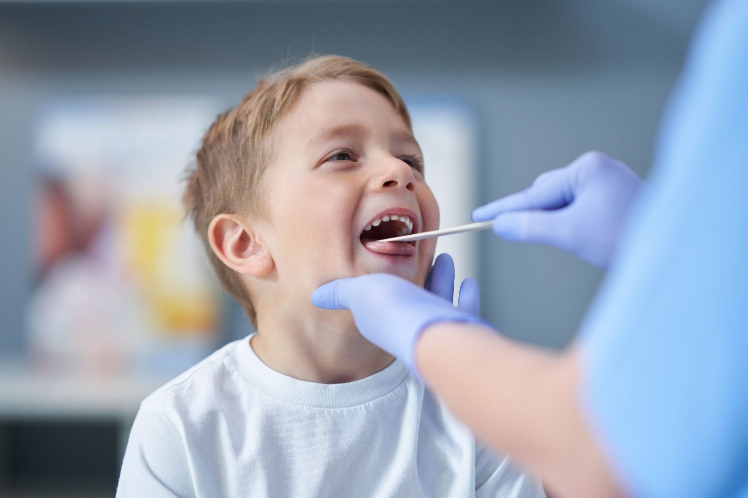 doctor inspecting young boy's mouth