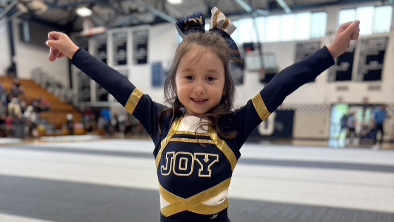 smiling young girl in a cheerleading uniform