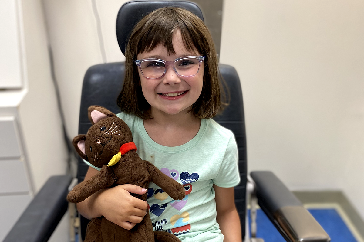 Emelia McCreight sitting in exam chair holding a stuffed animal