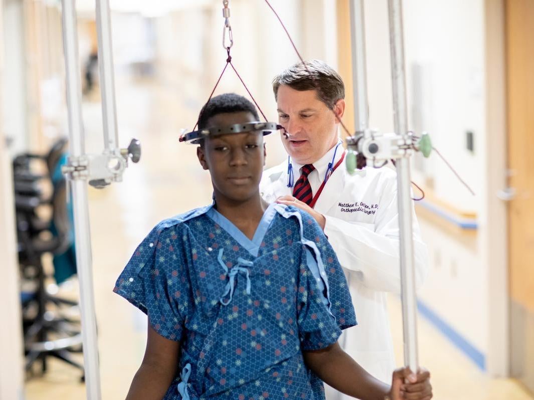 young male patient receiving spinal traction treatment for scoliosis