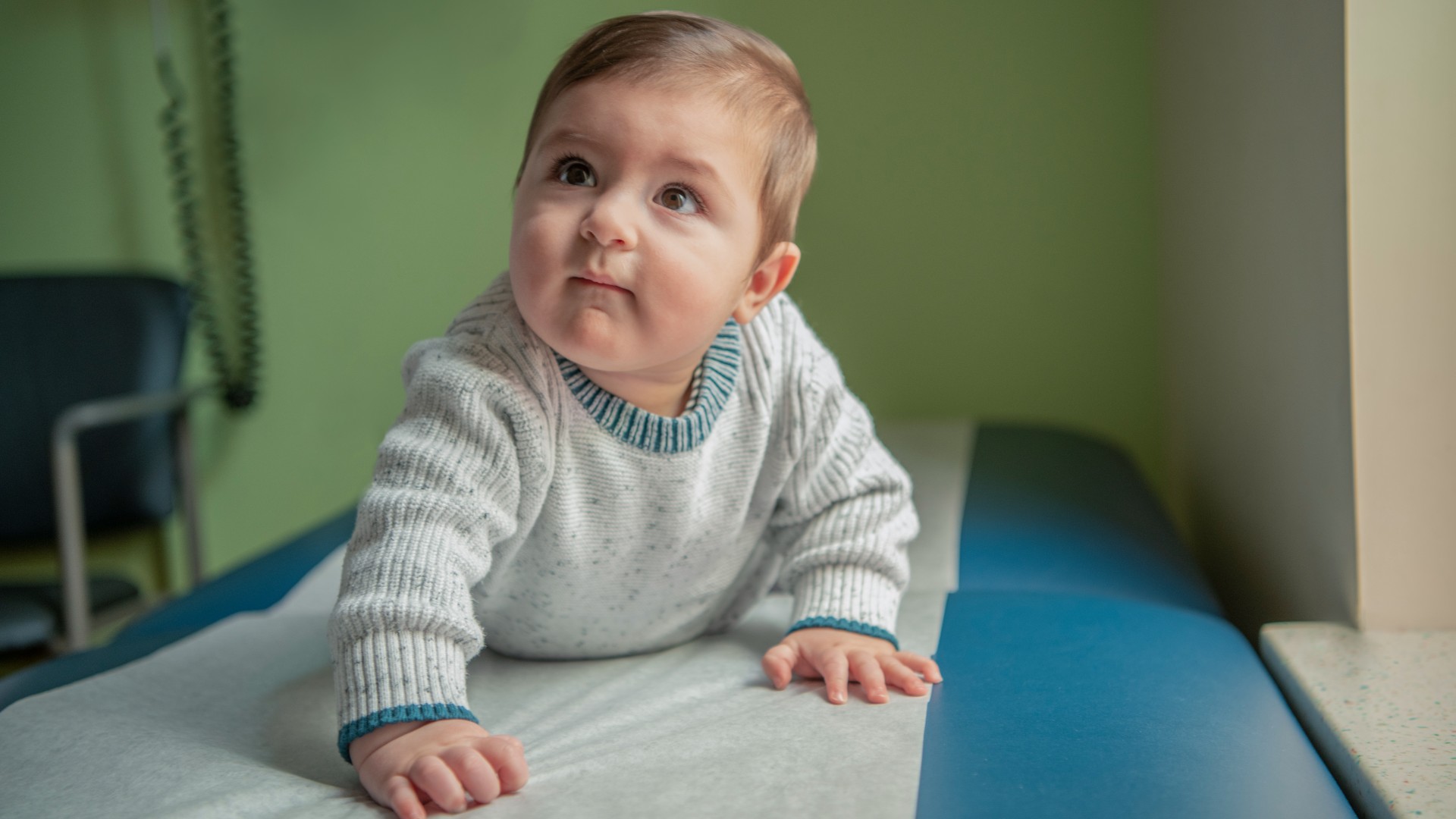 Baby crawling on exam table