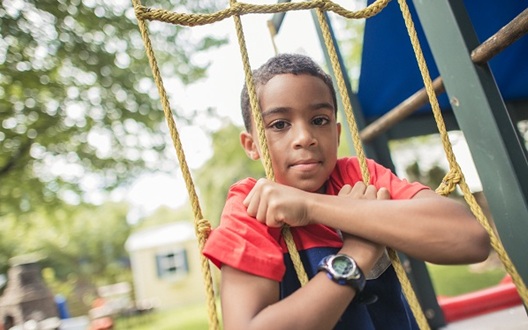A boy in a red t-shirt playing on the playground