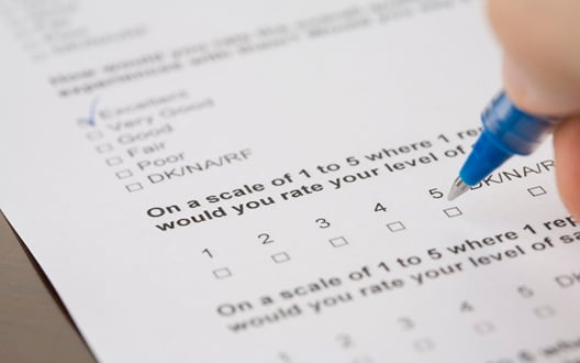 Person taking a paper survey with a pen