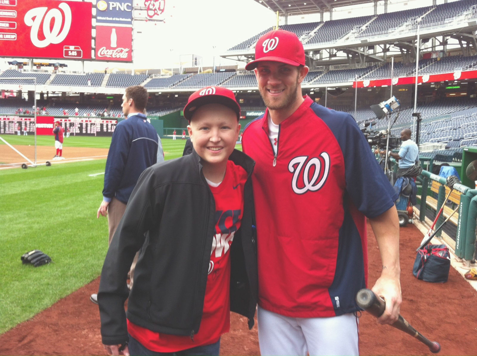 Marco smiling while standing next to Washington Nationals player Bryce Harper at Nationals Park