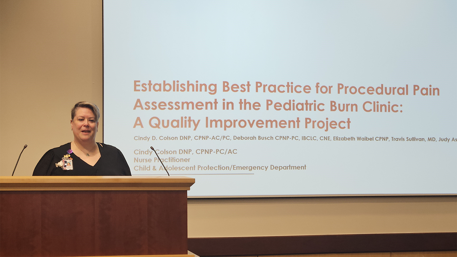 Cindy Colson presenting at a podium.