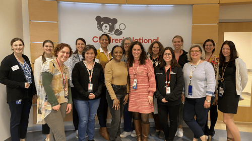 Group photo in front of the interior Children's National Hospital sign.