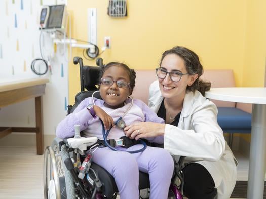 doctor smiling next to patient in wheelchair