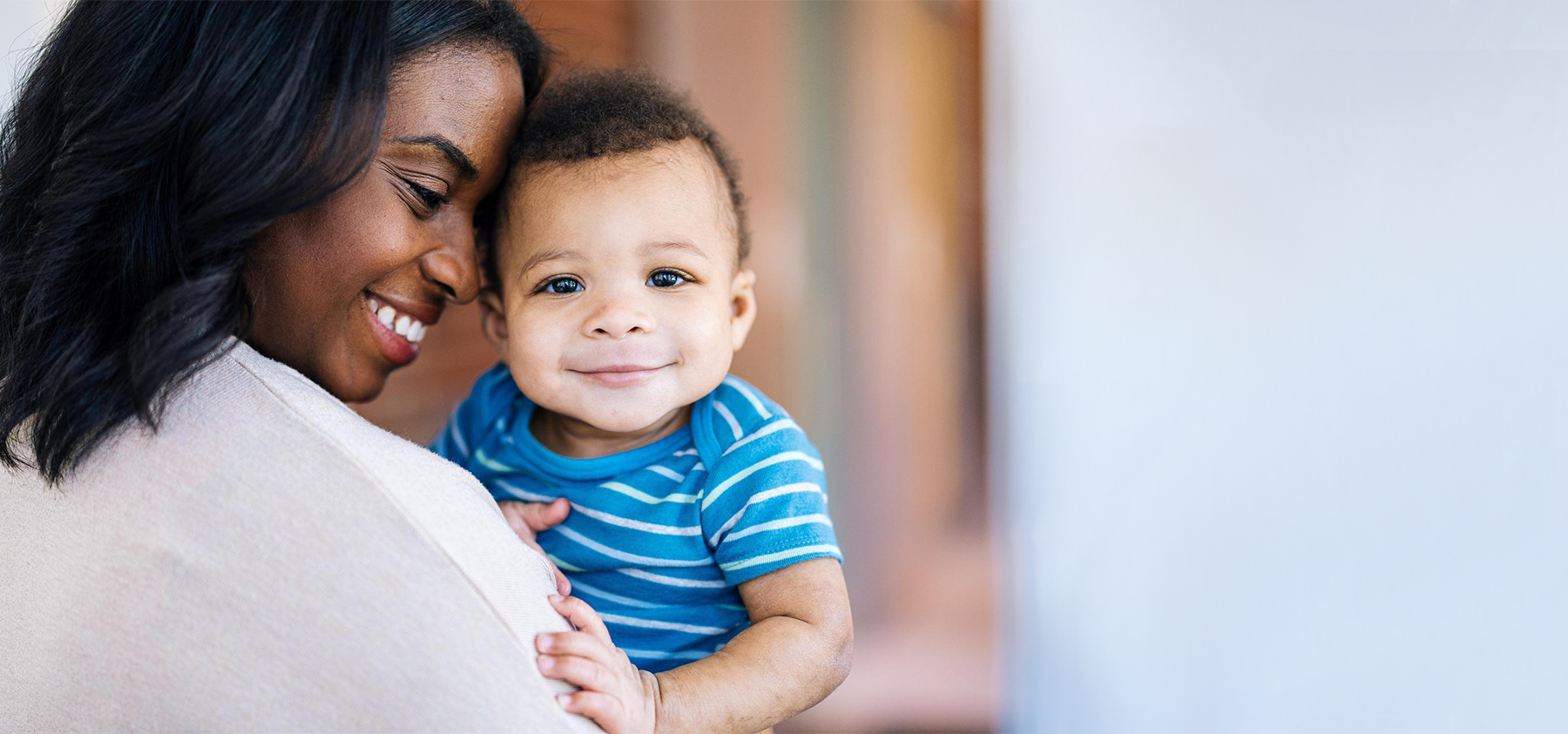 Baby and his mom smiling together