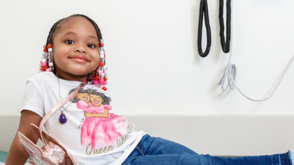young girl smiling on exam table