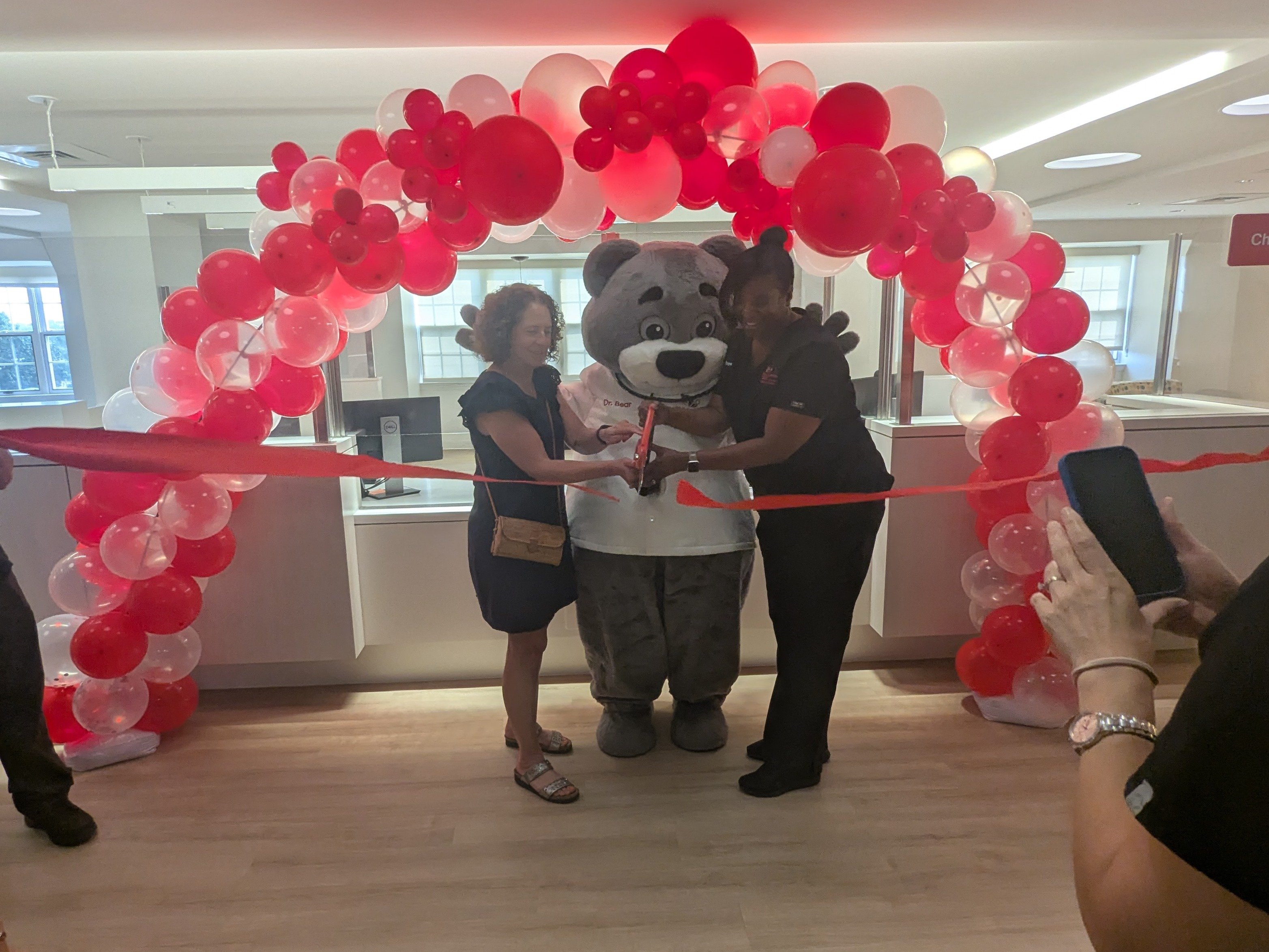 Two providers and Dr. Bear cutting the ribbon at CNPA Capitol Hill's new location