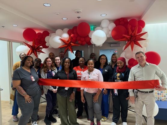 Group of employees cutting ribbon at new location