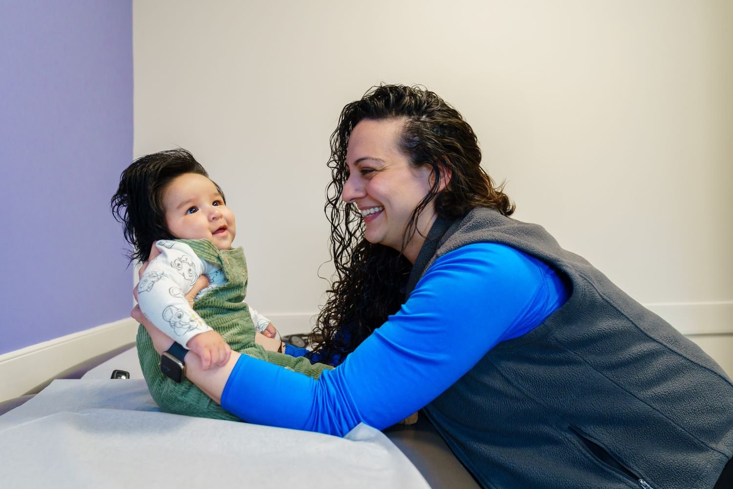 smiling doctor examines baby