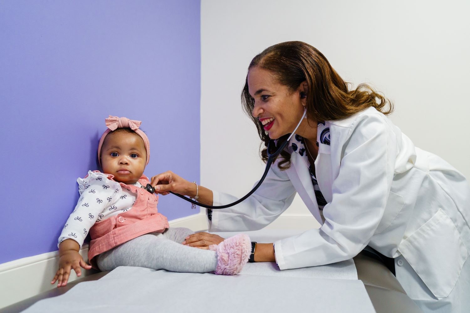Pediatrician listening to baby girl's heart