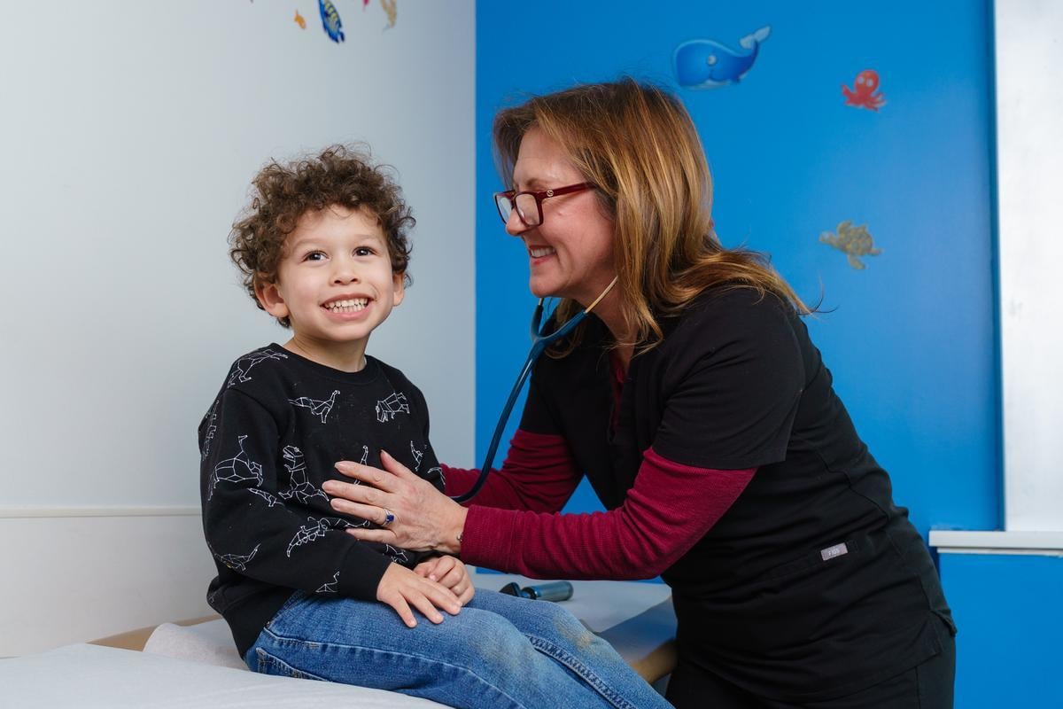 Doctor listening to child's heart