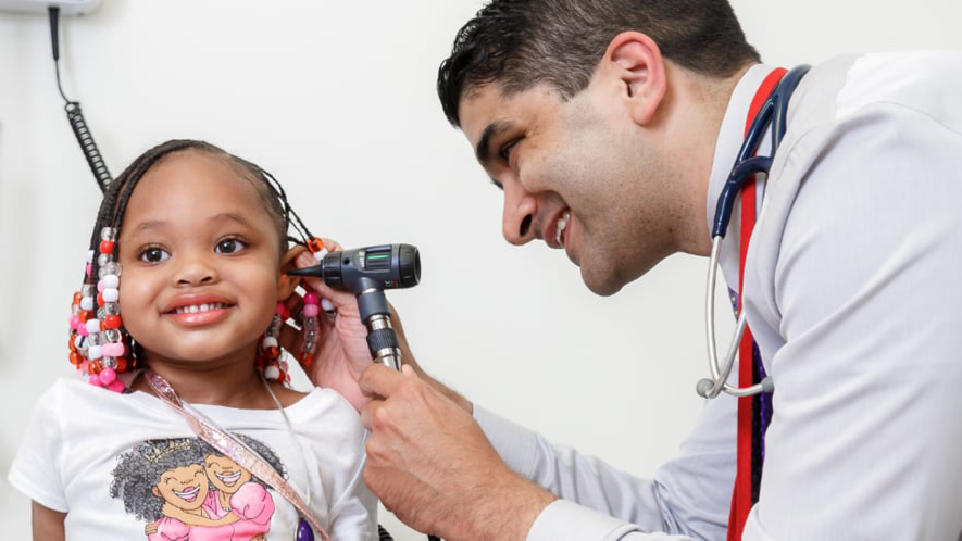 Provider examining young girl's ear