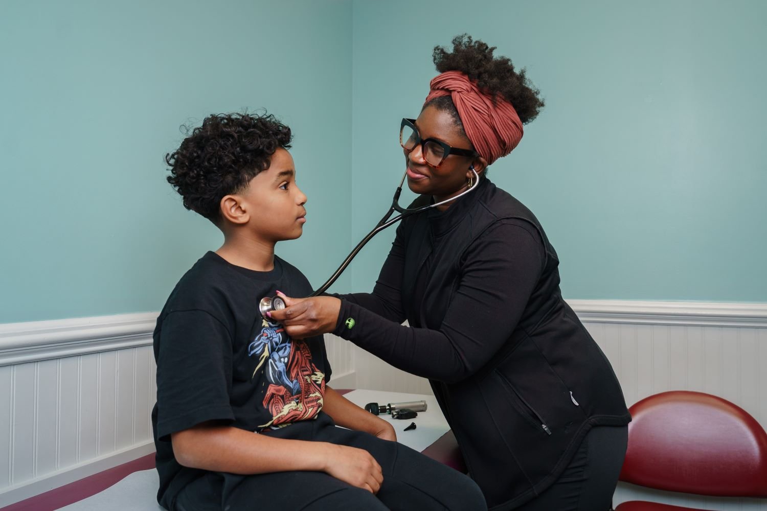provider listens to patient's heart with stethoscope