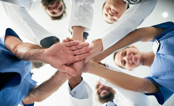 A group of doctors and nurses doing a hand pile