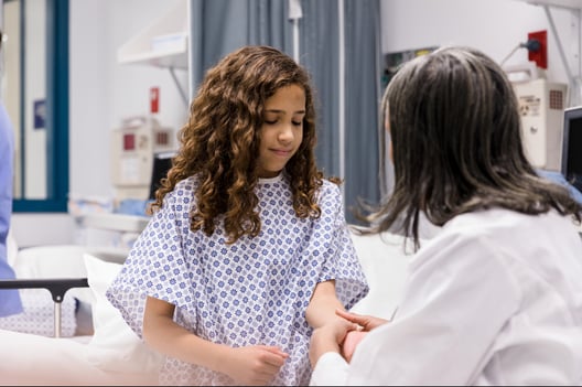A doctor examines a girl's arm
