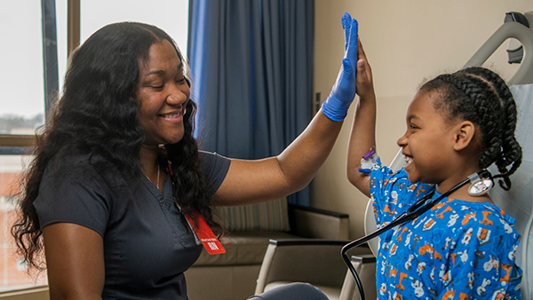 A nurse giving patient Ashley Moore a high five