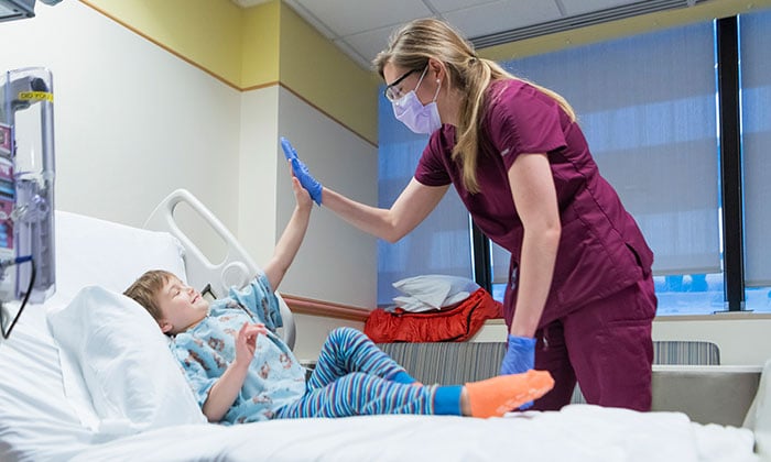 Boy giving high five to a nurse