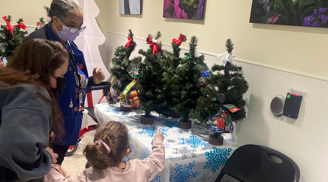 A young female patient choosing a miniature Christmas tree