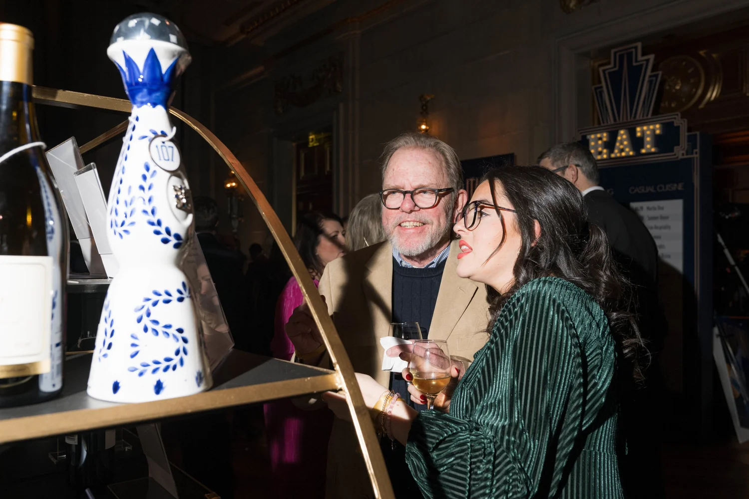 Two A Vintage Affair 2025 attendees inspect auction items.