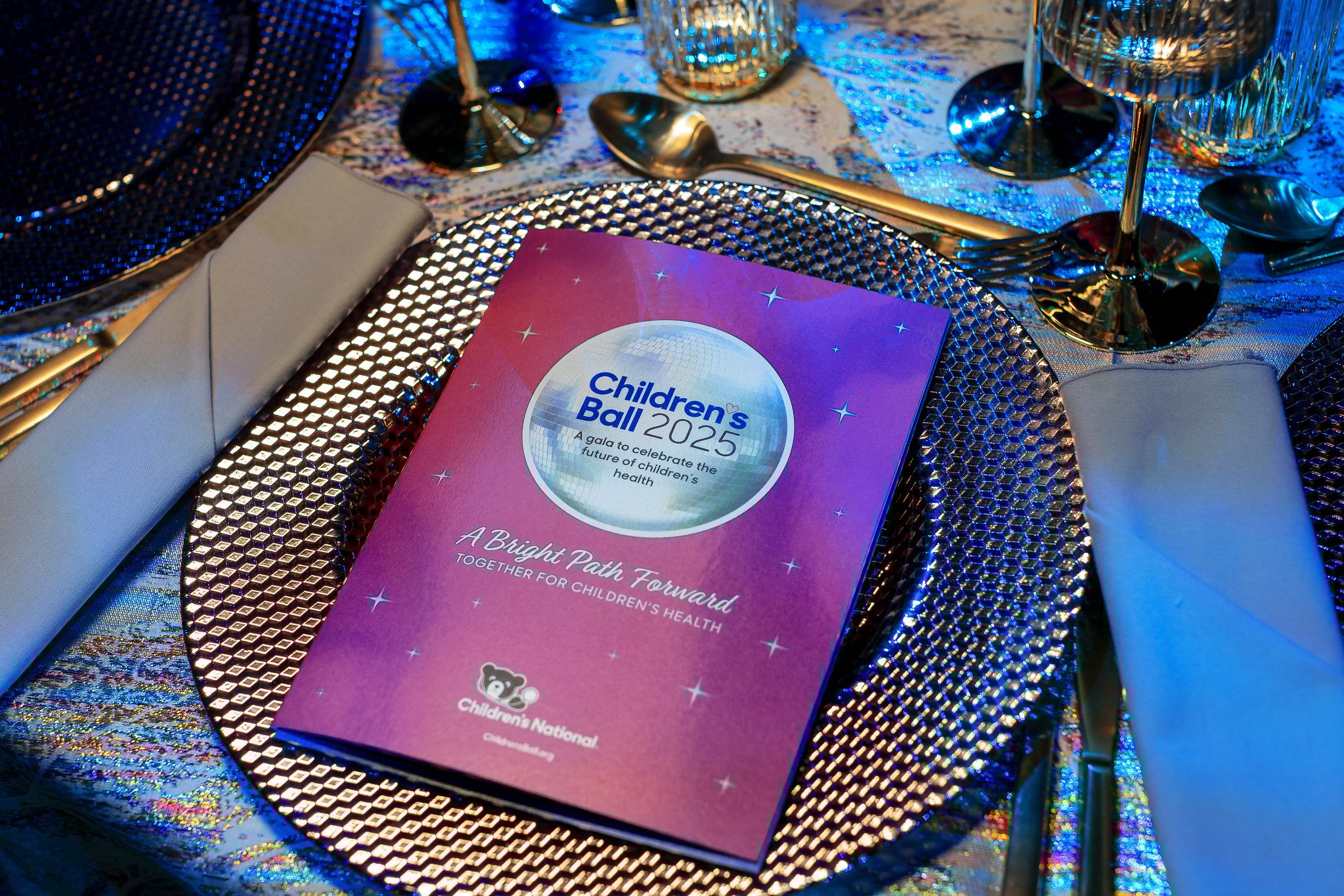 Table place setting with Children's Ball 2025 event pamphlet