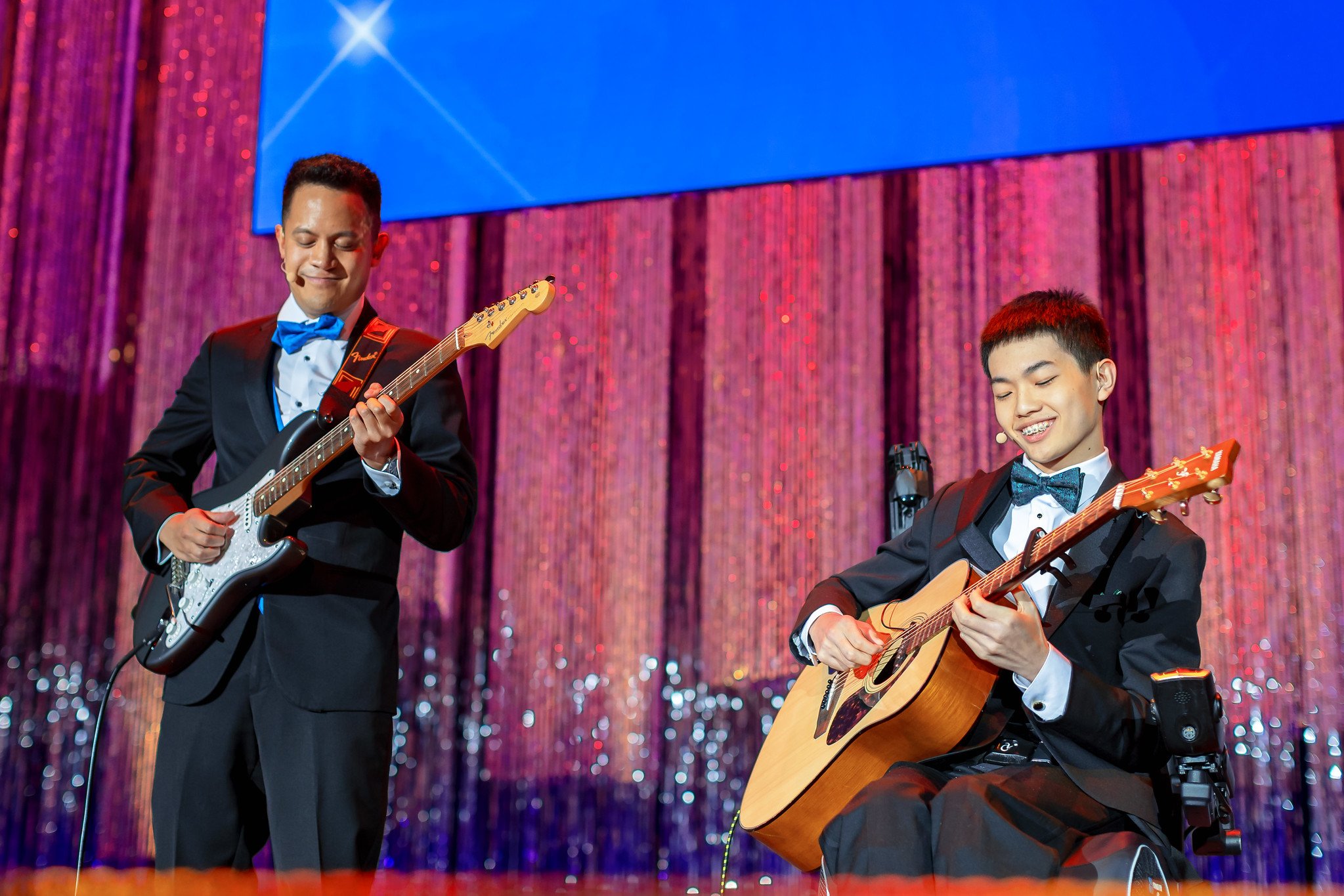 Max, a Children's National patient ambassadors, playing guitar on stage