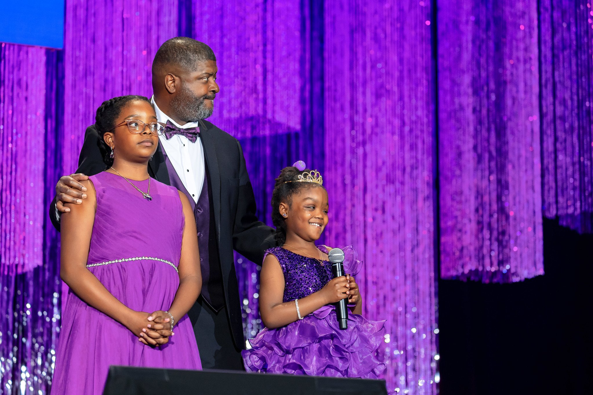 Raci, a Children's National patient ambassador, and her family standing together on stage