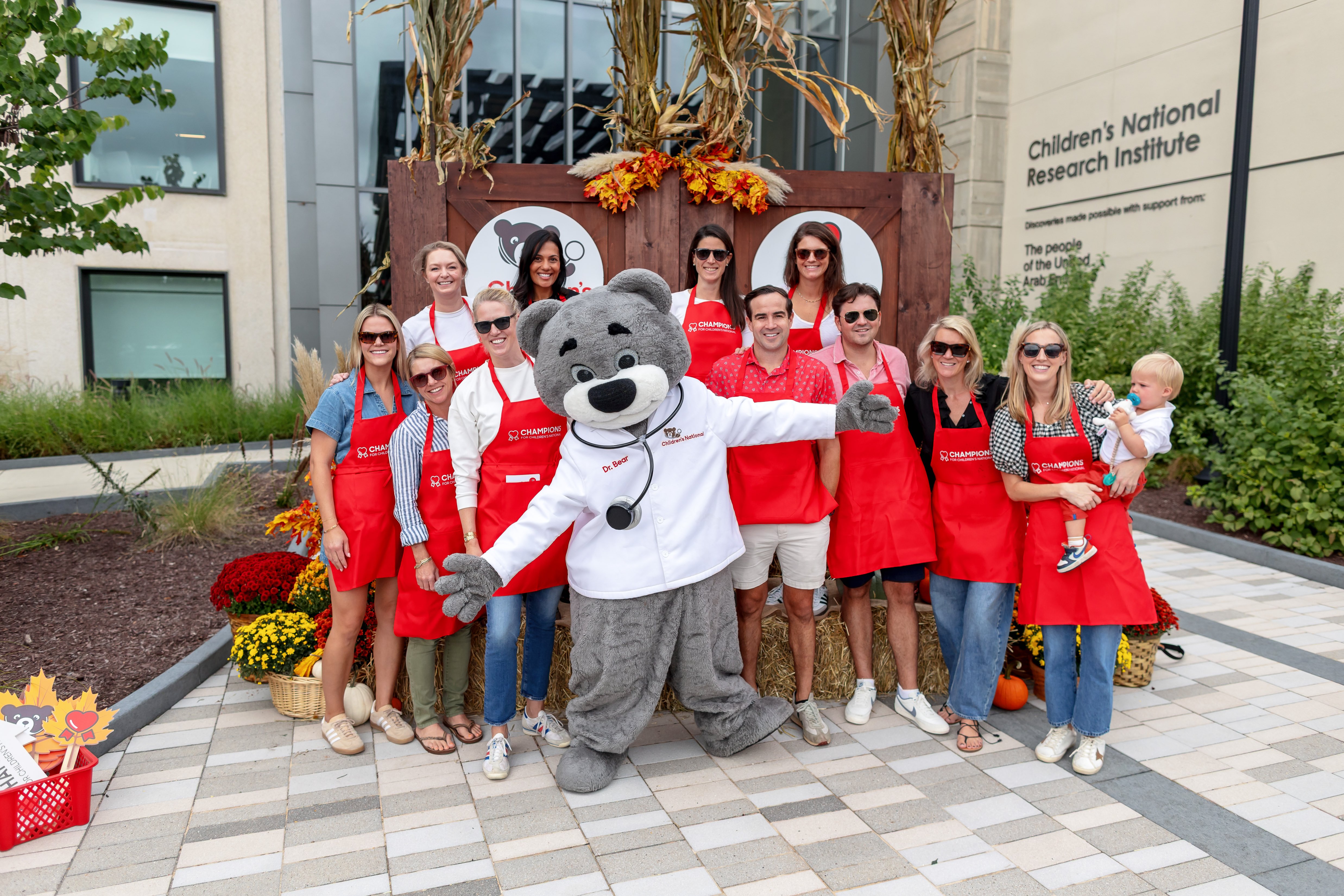 Champions for Children's National volunteers pose with the Dr. Bear mascot.