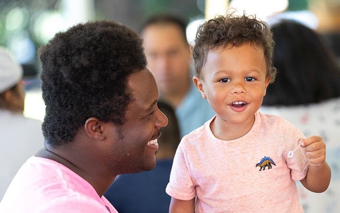 A father and toddler at a fundraising event.