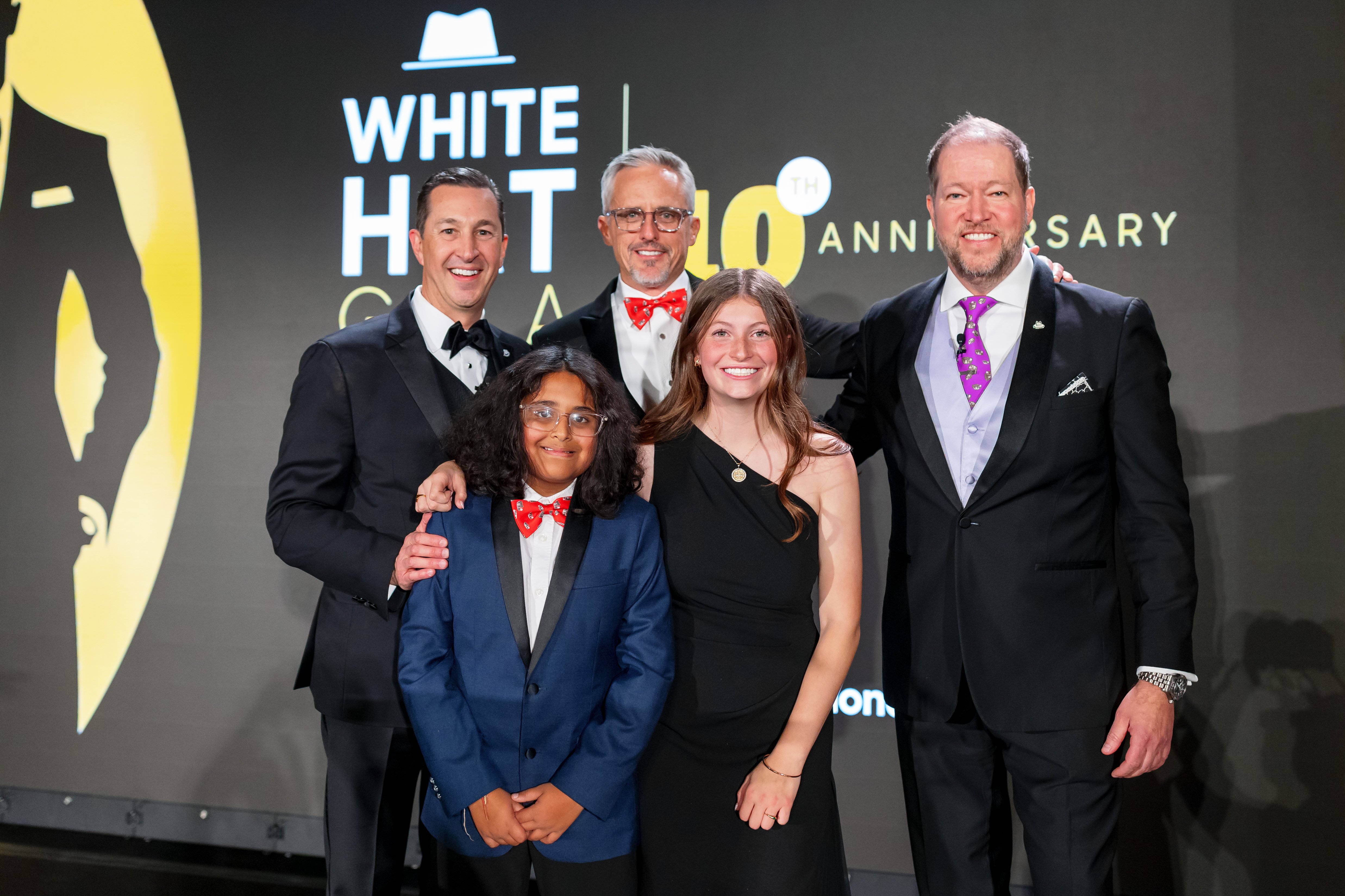 Patient ambassadors and event co-chairs pose for a picture on stage at the White Hat Gala 2026.