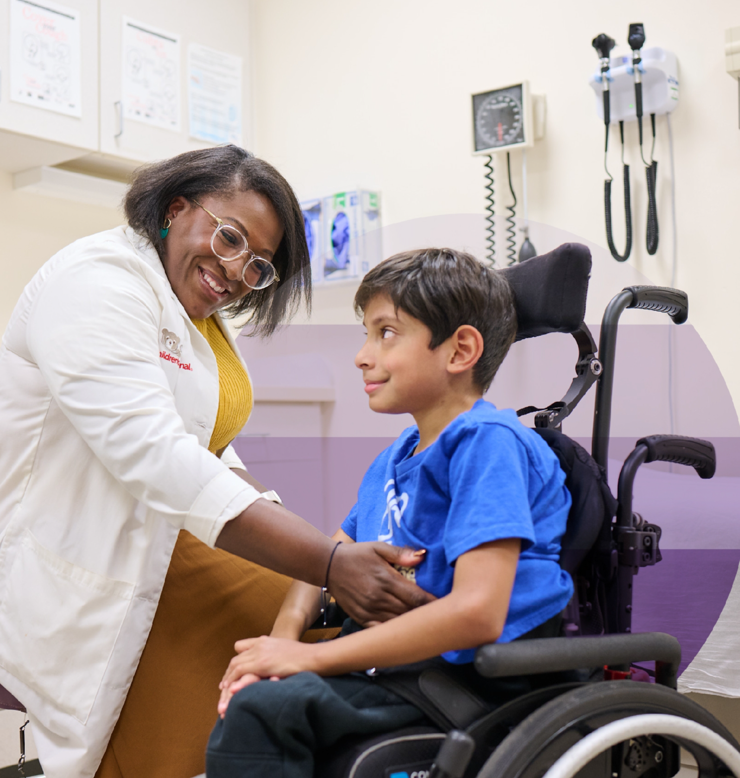 A female physician examines a young patient in a wheelchair.