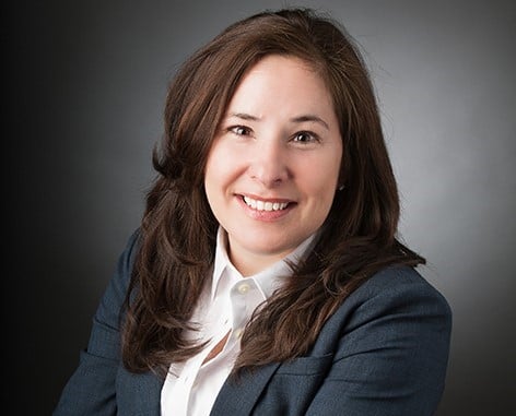 Tamara Sperling wearing a suit and smiling.