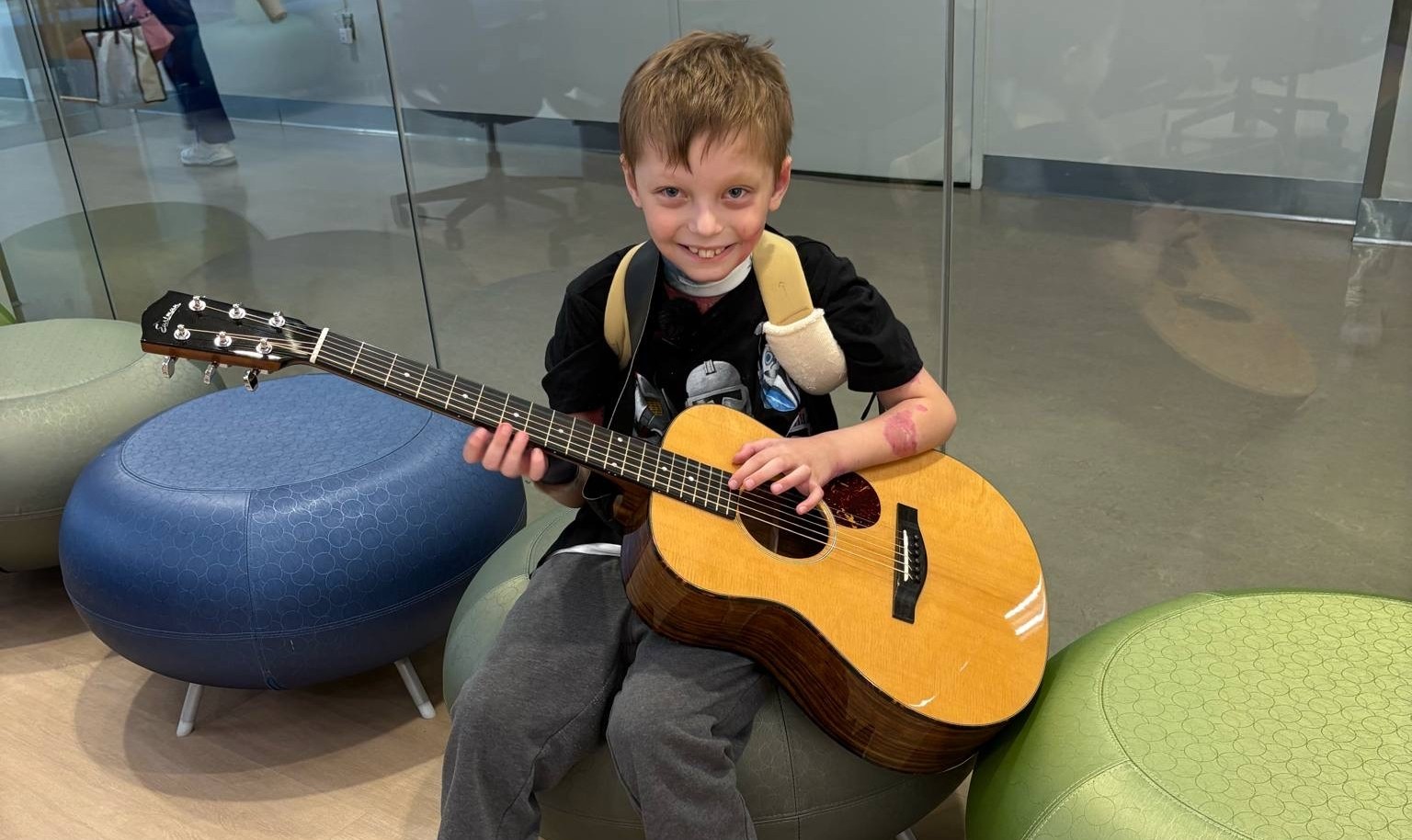 Children's National Hospital patient, Braden, playing acoustic guitar.