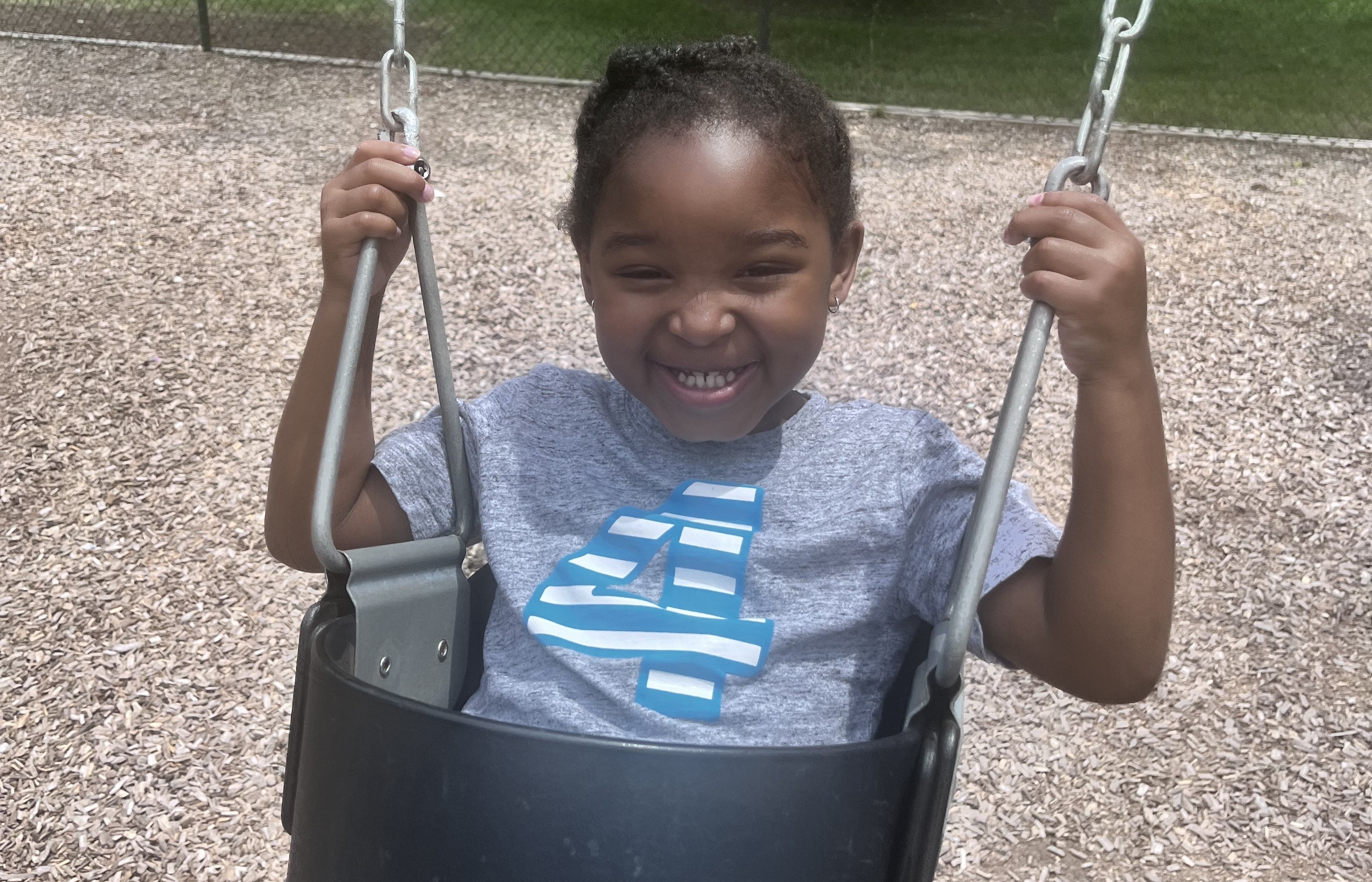 Four-year old Eden enjoys a swing at a playground.