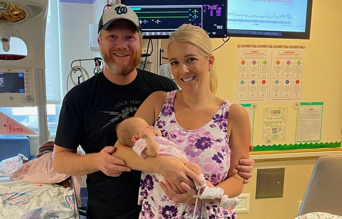 Fiona's parents holding her as an infant while she receives treatment at Children's National Hospital.