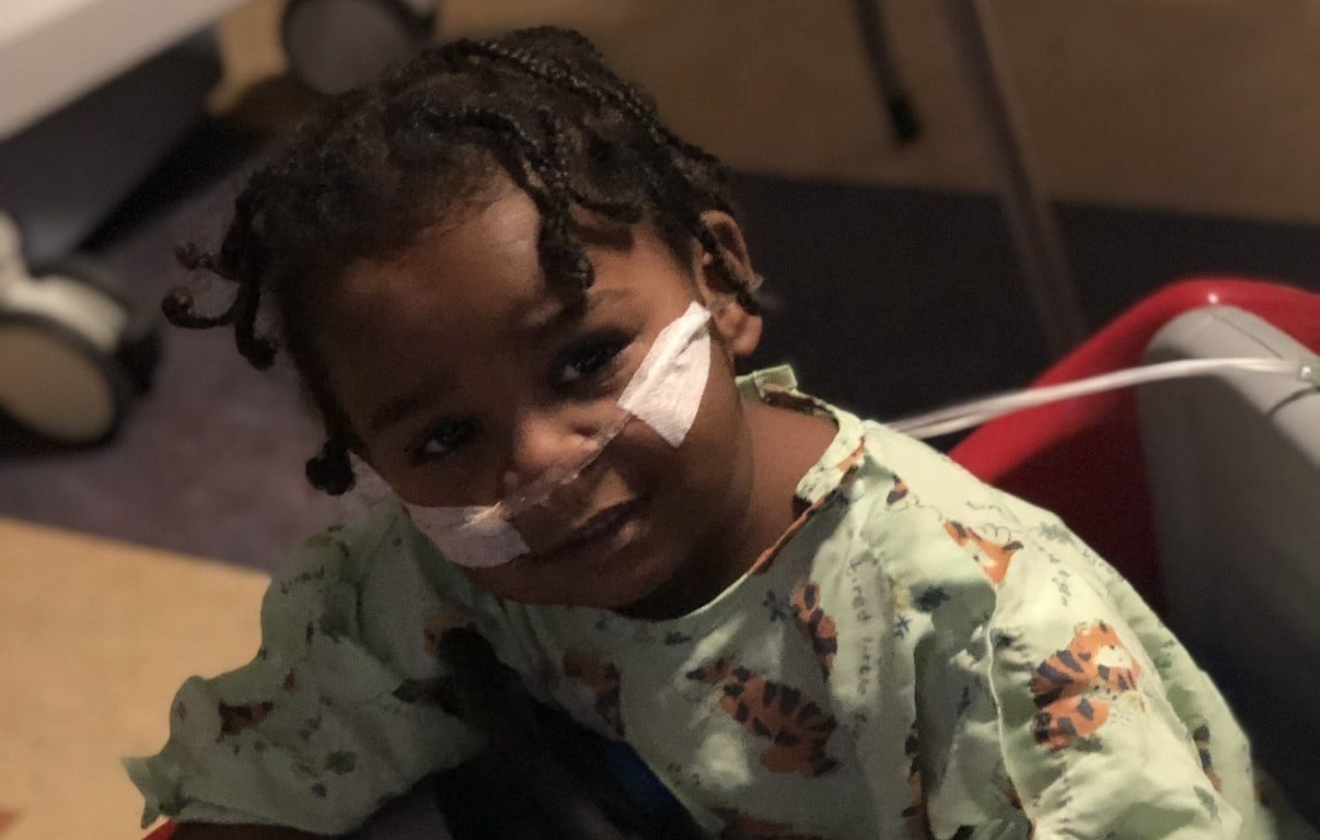 CNH patient, Karter, wearing a hospital gown and receiving supplemental oxygen.