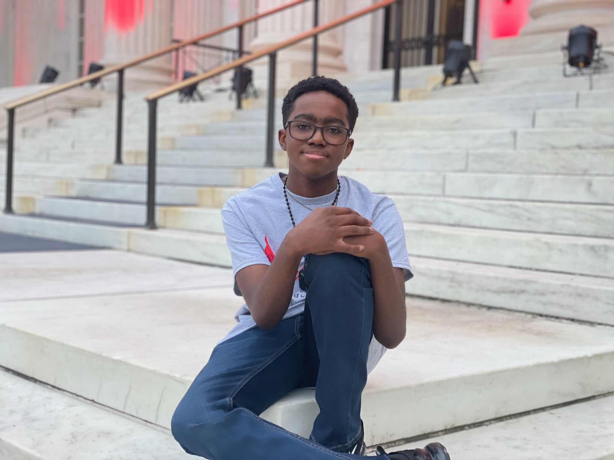 Kendric posing in seated position on stairs