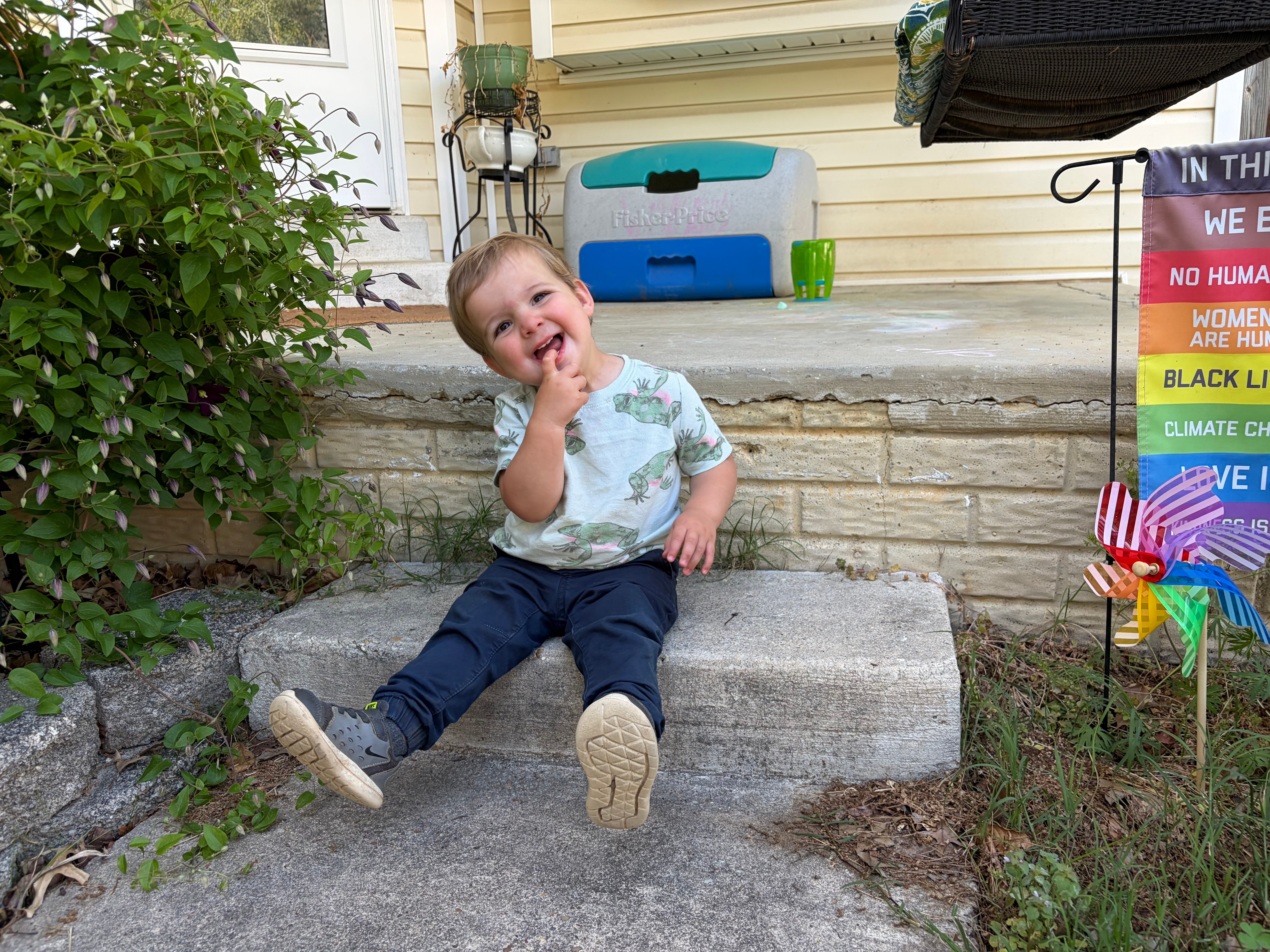 Kieran, the child of Kiley, a CNH patient, sits and smiles outside.